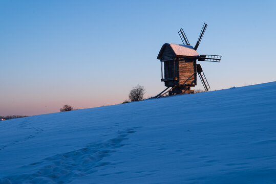 Ukrainian village, wooden windmill. Seasonal landscape. Winter