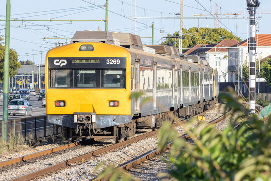 Cp commuter train traveling on railway tracks in lisbon