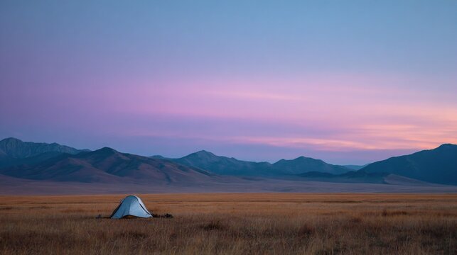 Peaceful campsite at sunset in a vast, mountainous landscape