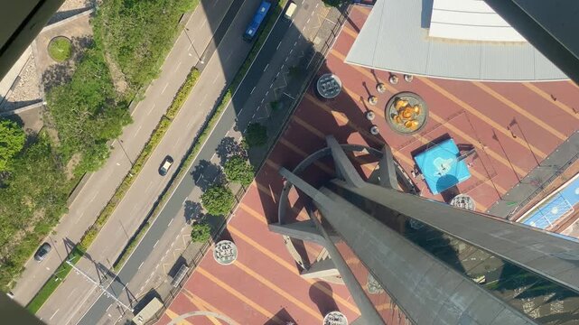 Downward View from Macau Tower Observation Deck Showing Tower Base and Shadow.