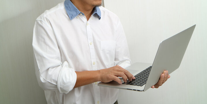 Man Using Laptop Computer While Standing at Home or Office