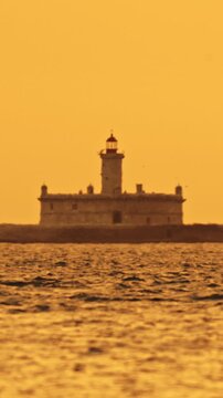 Bugio Lighthouse at orange foggy sunset