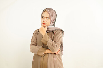 Fototapeta premium Indonesian Muslim Woman Use Headscarf with Thoughtful Expression and Pondering Gesture Isolated on White Background, finger on chin