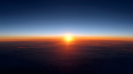 Fototapeta premium Magnificent aerial view of a vibrant sunset with the golden sun low on the horizon illuminating a sea of clouds and a colorful sky