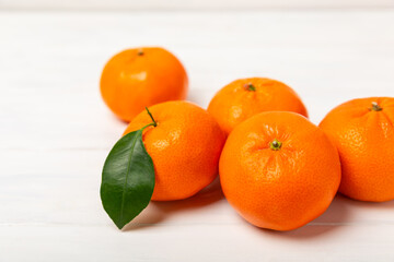 Fresh, ripe, juicy tangerines on the table. Whole and halved tangerines, clementines with green leaves. Citrus fruits. Tangerine or clementine. Fresh oranges. Vitamin C. Natural vitamin. Orange. Space