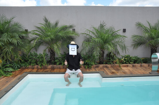 homem an&ocirc;nimo com rosto c&ocirc;mico feliz de f&eacute;rias na piscina f&eacute;rias de  ver&atilde;o 
