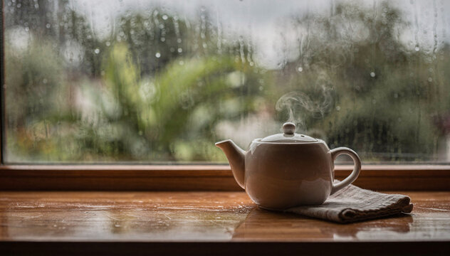 Warm Teapot on Wooden Sill with Rainy Window View - Cozy Indoor Scene