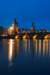 Obraz premium Charles Bridge (Karlův most) Illuminated at Night, Prague, Czech Republic – Golden Reflections on Vltava River