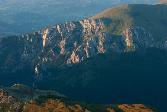 View of dramatic mountain slopes with stark rock faces contrast against the green hillsides under a serene sky, Jamnik, Zilinsky kraj, Slovakia.