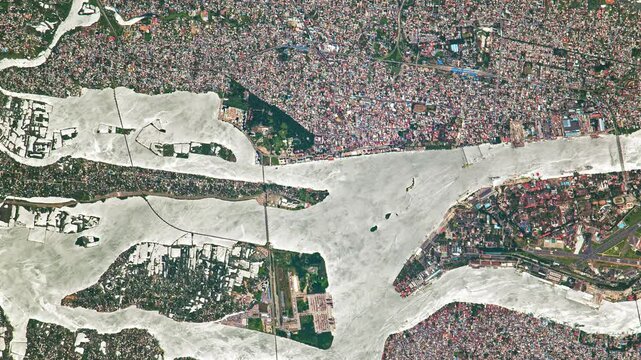 Top shot on slums in big city with river. Camera is moving right and up. Animation based on image by NASA