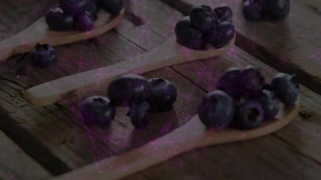 Camera pushing in, pulling focus to foreground spoon while light streaks highlighting blueberries