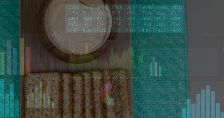 Displaying wooden board with frothy cup and seeded crackers near teal mat, showing data overlay
