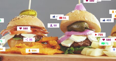 Featuring three gourmet sliders sitting on wood board at studio, with fries and social overlays © vectorfusionart