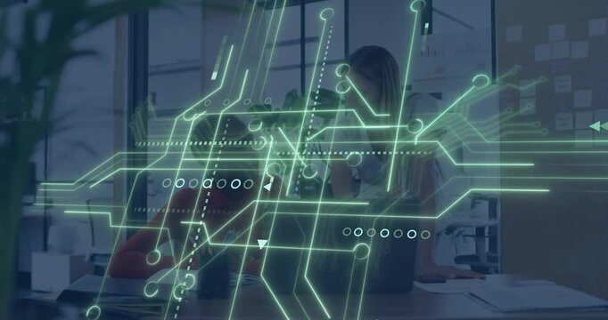 Two women collaborating at desk, animated green circuit sweeping revealing laptop for business task