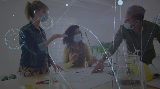 Design team pointing at plans discussing and causing animated overlays appearing and focusing plan