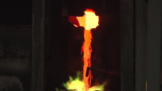 Industrial Metal Casting Scene With Colorful Molten Stream And Chemical Reactions From Factory Viewpoint . Stock clip