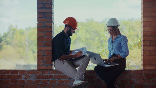 Engineers Coordinating Development Task. Reviewing Project Documentation In Unfinished Brick Structure