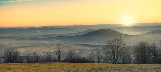 mglisty poranek nad wiejskim krajobrazem z rozległą górską panoramą © piotr
