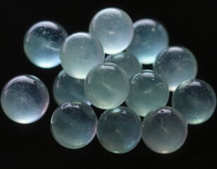 A captivating cluster of translucent, aquamarine glass spheres, each subtly unique and illuminated, scattered artfully against a dark, contrasting background, evoking a sense of calm and mystery