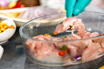 Preparing fish ceviche mixing fresh fish in bowl