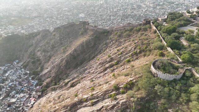4K aerial of Nahargarh Fort wall on the ridge overlooking Jaipur, Rajasthan, India. Historic architecture, city panorama, daylight.