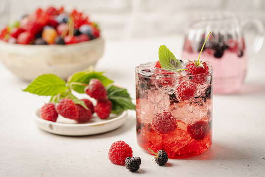 Glass of berry cocktail or drink soda with fresh berries on white background