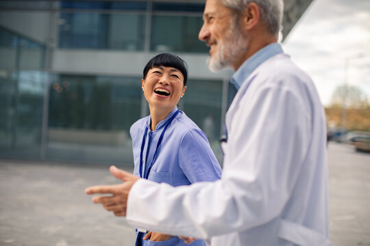 Two healthcare professionals laughing outside hospital