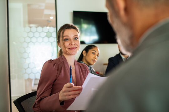 Smiling businesswoman leading meeting in modern office