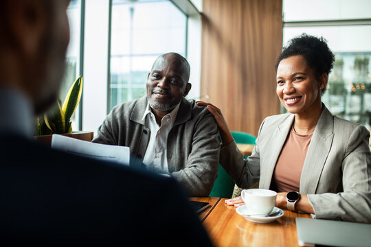 Smiling couple meeting financial advisor in modern office