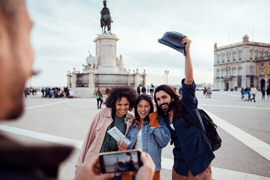 Happy friends posing for travel photo in european city square