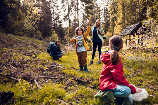 Family hiking and picking up litter in sunny forest