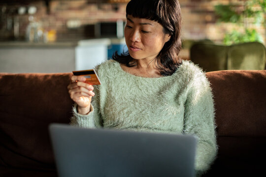 Woman shopping online at home with credit card