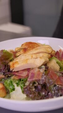 Closeup chef ipresenting delicious caesar salad on camera. slow motion. High quality FullHD footage