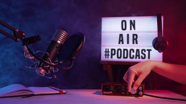Professional Podcast Recording Setup with Microphone and On Air Sign, a hand is adjusting knobs
