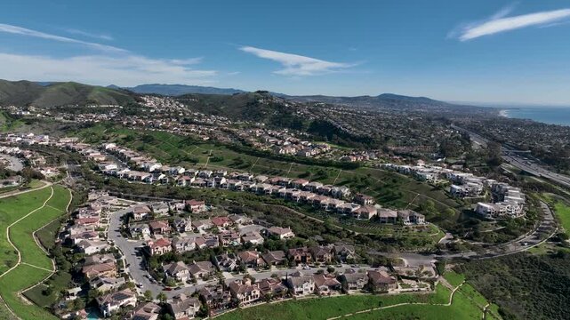Aerial view over San Juan Capistrano, California, featuring the historic mission, library, sports courts, and an Amtrak train pulling into the downtown station. High quality 4k footage