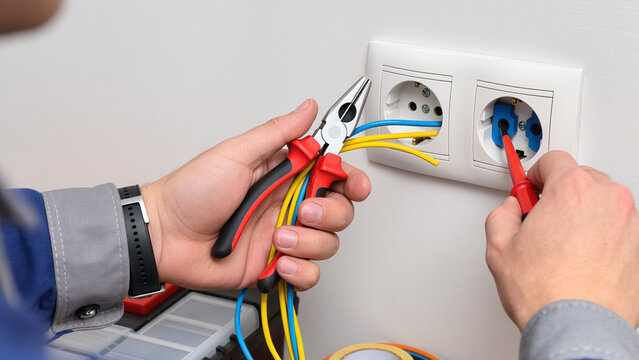 electrician fixing electrical outlet