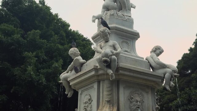 Historic stone fountain with sculpted faces in Santa Cruz de Tenerife park 
