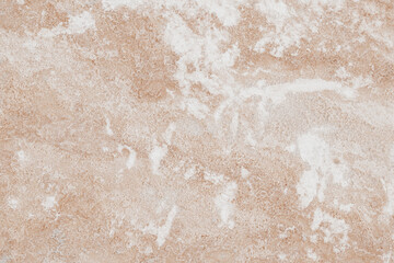 Close-up of natural stone texture with coral and ginger orange tones. Rough rocky surface pattern