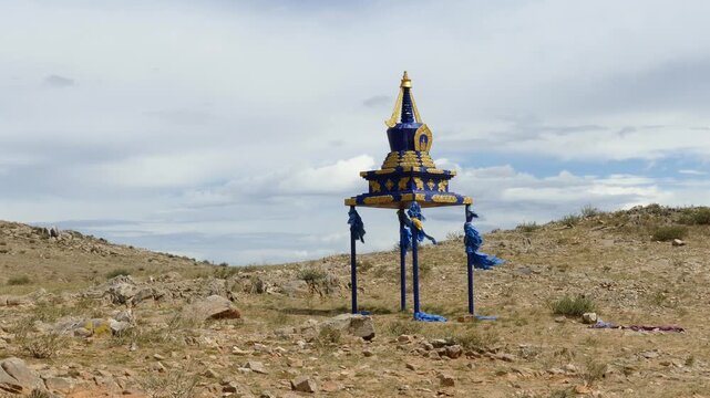 Buddhist sacred building of stupa on the background of the picturesque cloudy sky in the Mongolian steppe. On a Sunny summer day.
