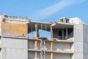 Unfinished building and construction structures against blue sky in city