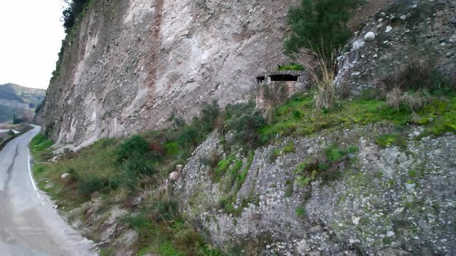 A concrete bunker in Tobruk. A pillbox on a cliff during Mussolini's time. Italian coastal fortifications during World War II. A defensive structure for machine guns or observers.