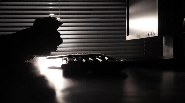 Silhouette hands counting banknotes on a desk in a dark room with a computer monitor, depicting themes of financial crime, illegal transactions, and illicit wealth
