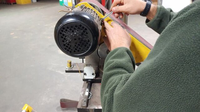 Close up of a technician repairing an industrial motor pump in a workshop."