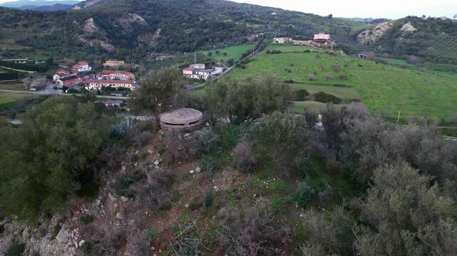 An Italian hilltop bunker from World War II. Drone footage shows a circular concrete pillbox, a piece of Italian military architecture from the fascist period, built by Benito Mussolini's forces.