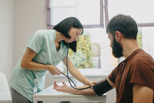 Nurse measuring patient's blood pressure in clinic
