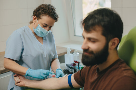 Nurse drawing blood from patient for medical examination