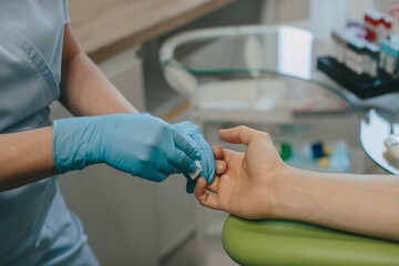 Medical professional performing finger stick blood test © dsheremeta