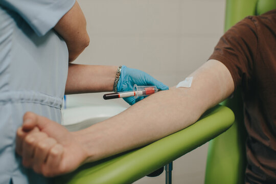 Nurse collecting blood sample from patient's arm