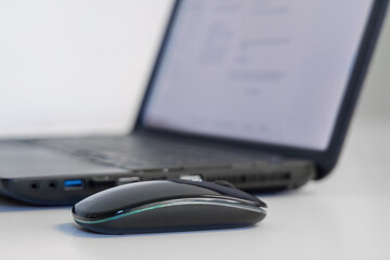 Computer mouse with laptop on white office desk workspace