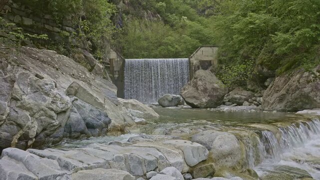 Water falls from man made cascade. Stunning waterfalls and natural beauty. Cascatella waterfall near Novate Mezzola, Italy.